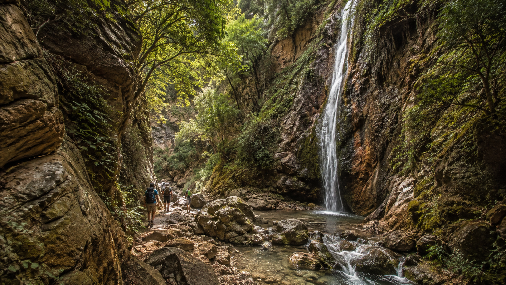 Φαράγγι της ανατολικής Κρήτης με νερό, σκιά και πυκνή βλάστηση.